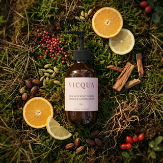 Vicqua skin body serum bottle surrounded by oranges, lemons, and spices on a mossy background