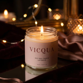 Vicqua soy wax candle with a lit flame on a dark background