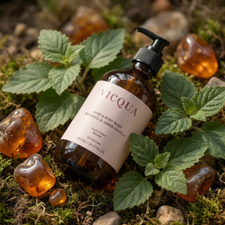Vicqua Hand & Body Wash Patchouli and Amber Vanilla bottle surrounded by patchouli leaves and amber resin