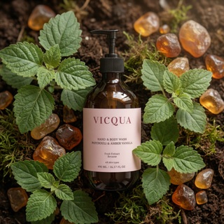 Vicqua Hand & Body Wash Patchouli and Amber Vanilla bottle surrounded by patchouli leaves and amber resin